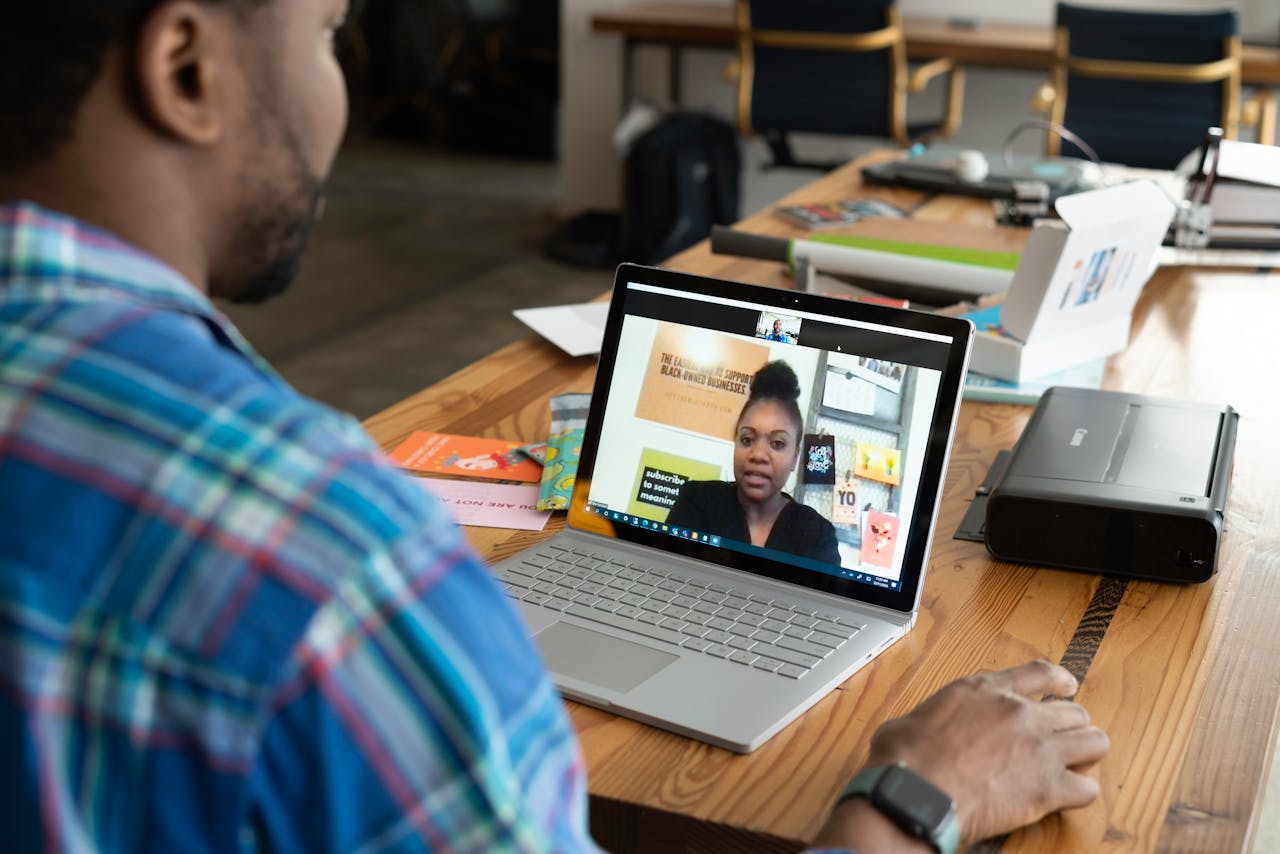 Offerings A businessman engaging in a virtual meeting using a laptop at an office desk.