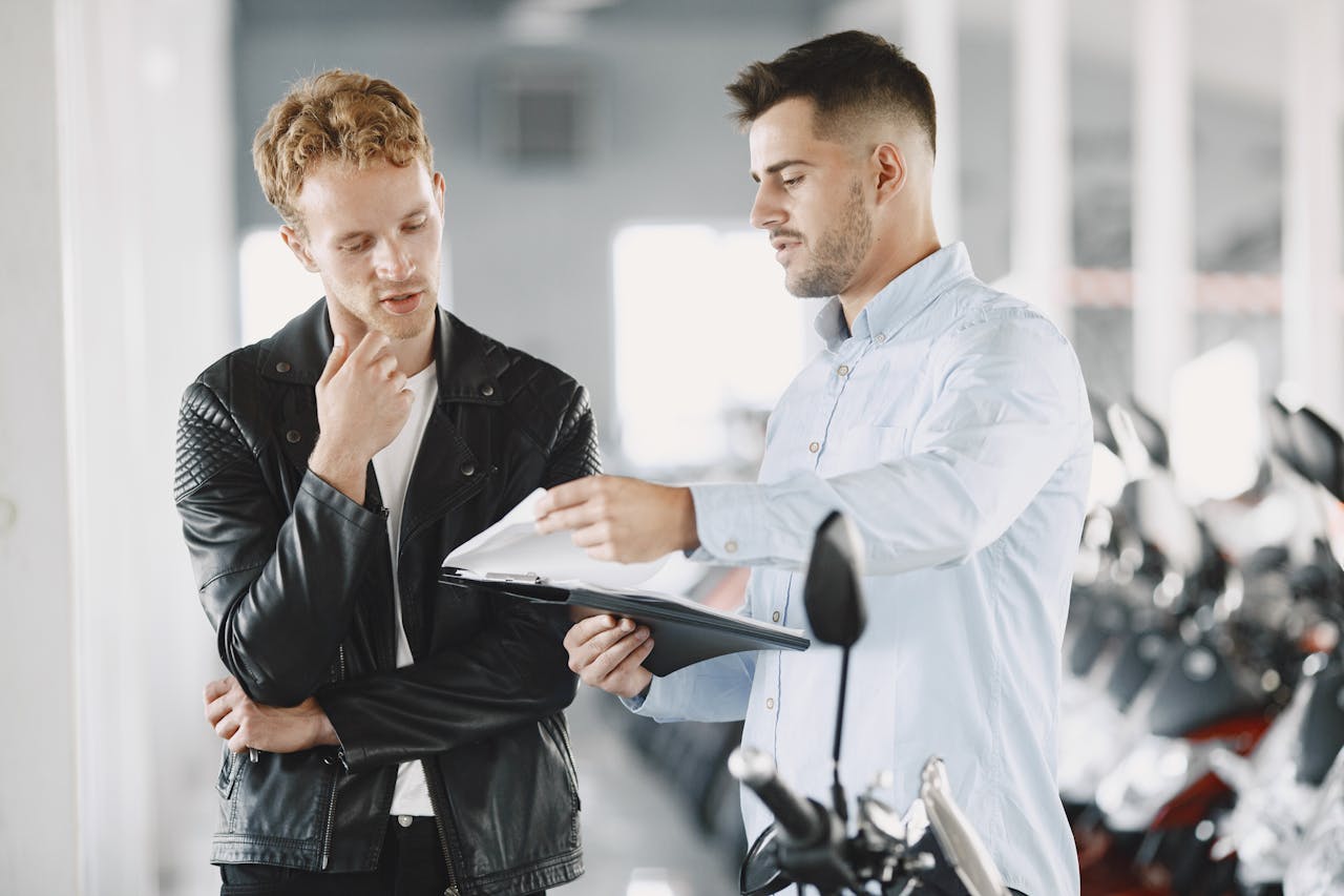 Offerings Two adults discussing purchasing options at a motorcycle dealership.